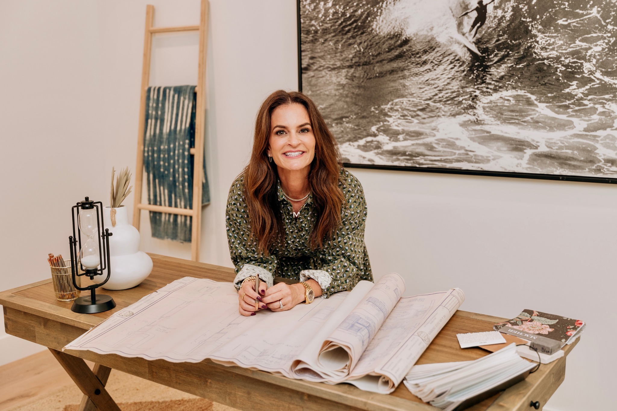 Marina Accardo leaning over a table with project plans and finish samples